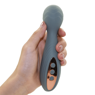 Hand holding a gray and rose gold electronic device on a white background